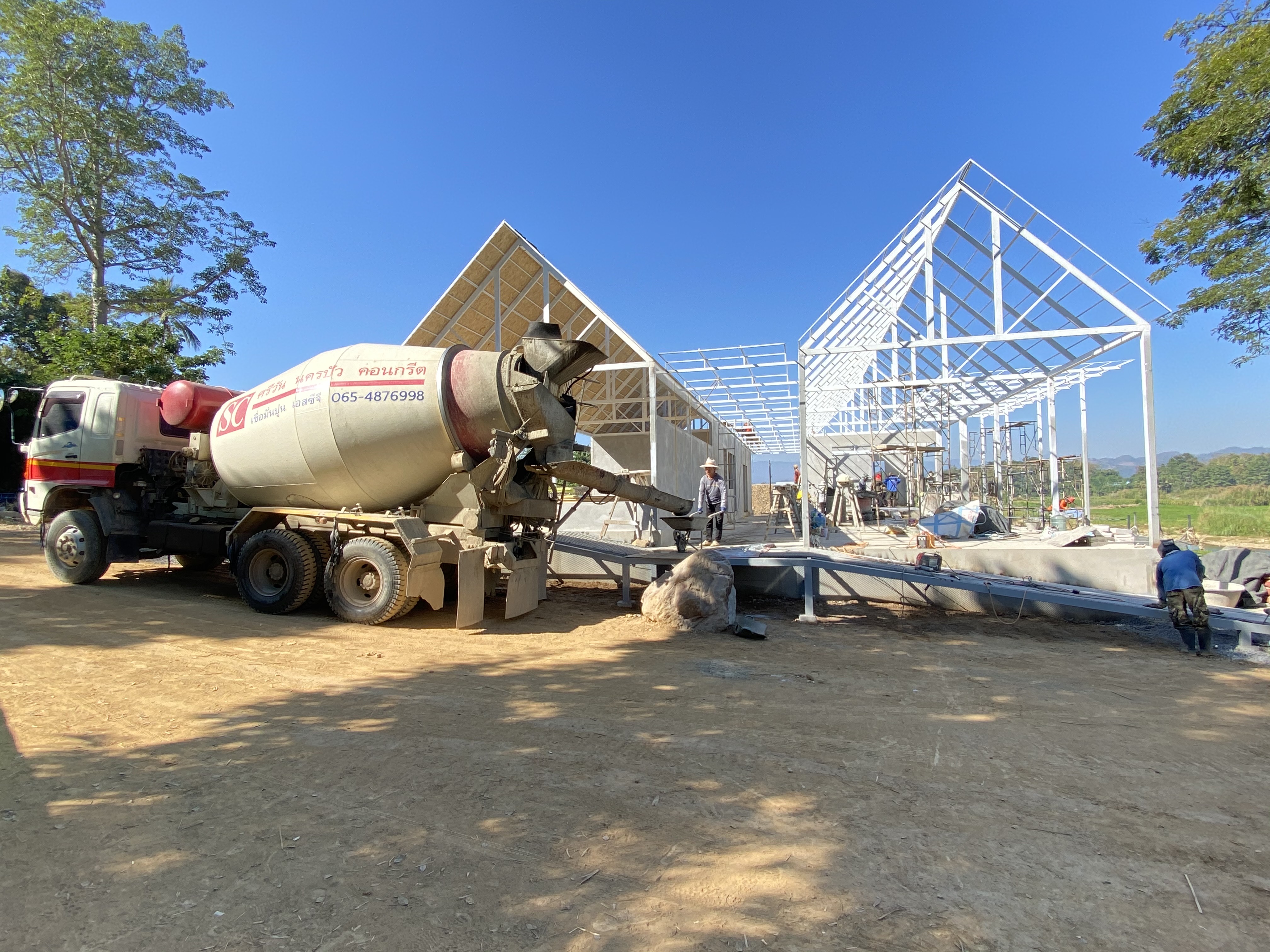 Mixer truck delivering concrete for a two-story residence
